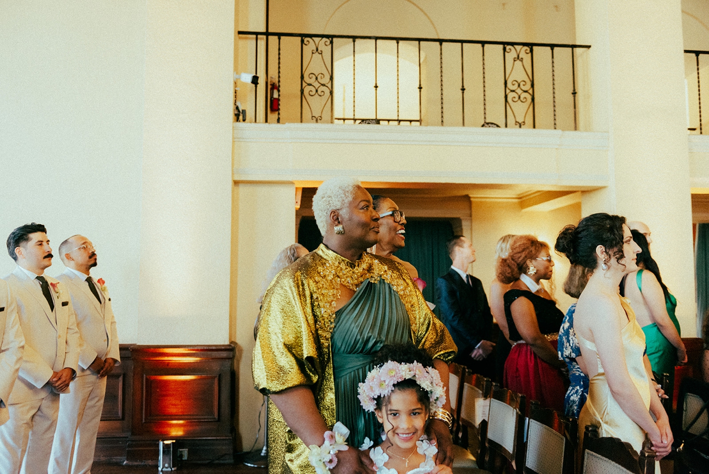 Wedding guests watching bride walk down the aisle